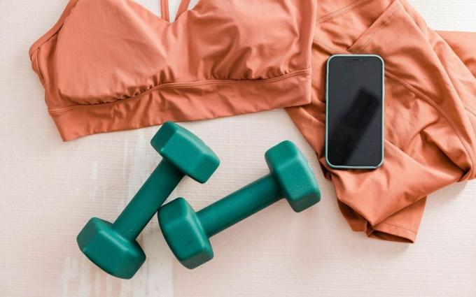 Sportkleding, dumbbells en smartphone flatlay