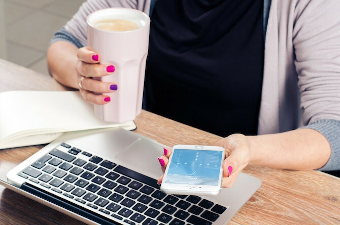 Vrouw koffie drinken op telefoon en Mac