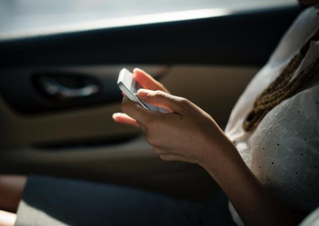 vrouw in auto op telefoon