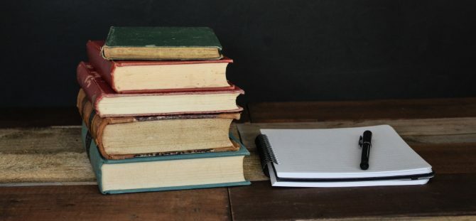 Stapel boeken en Kladblok voor onderzoek