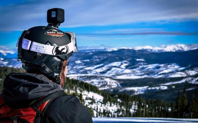 Man in helm met actiecamera kijken naar Snow Mountain